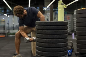 Uma pessoa fazendo exercício na academia enquanto está com a sua garrafa térmica Aerolight Fast Flow para manter a hidratação